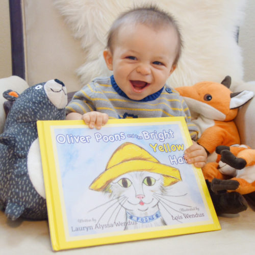 Baby smiling with Oliver Poons and the Bright Yellow Hat